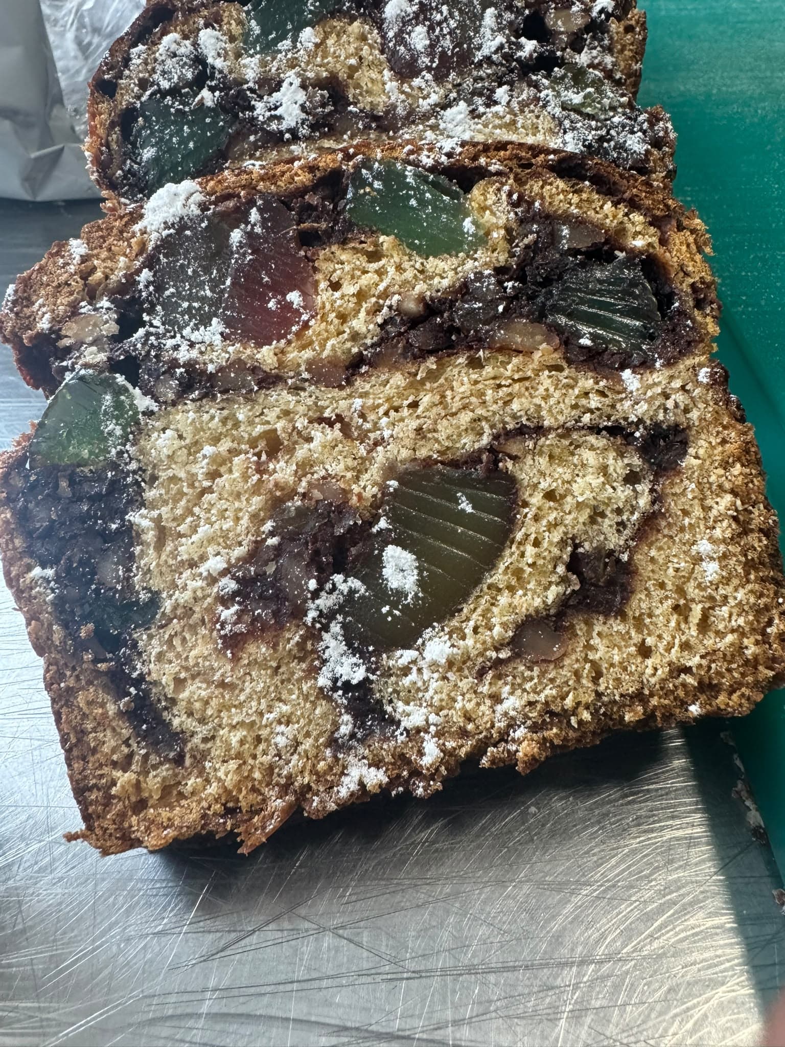 Slice of homemade cozonac with walnuts and Turkish delight, dusted with icing sugar