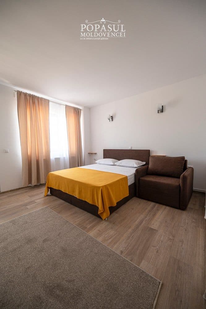 Pat matrimonial și canapea, cu lumină naturală de dimineață